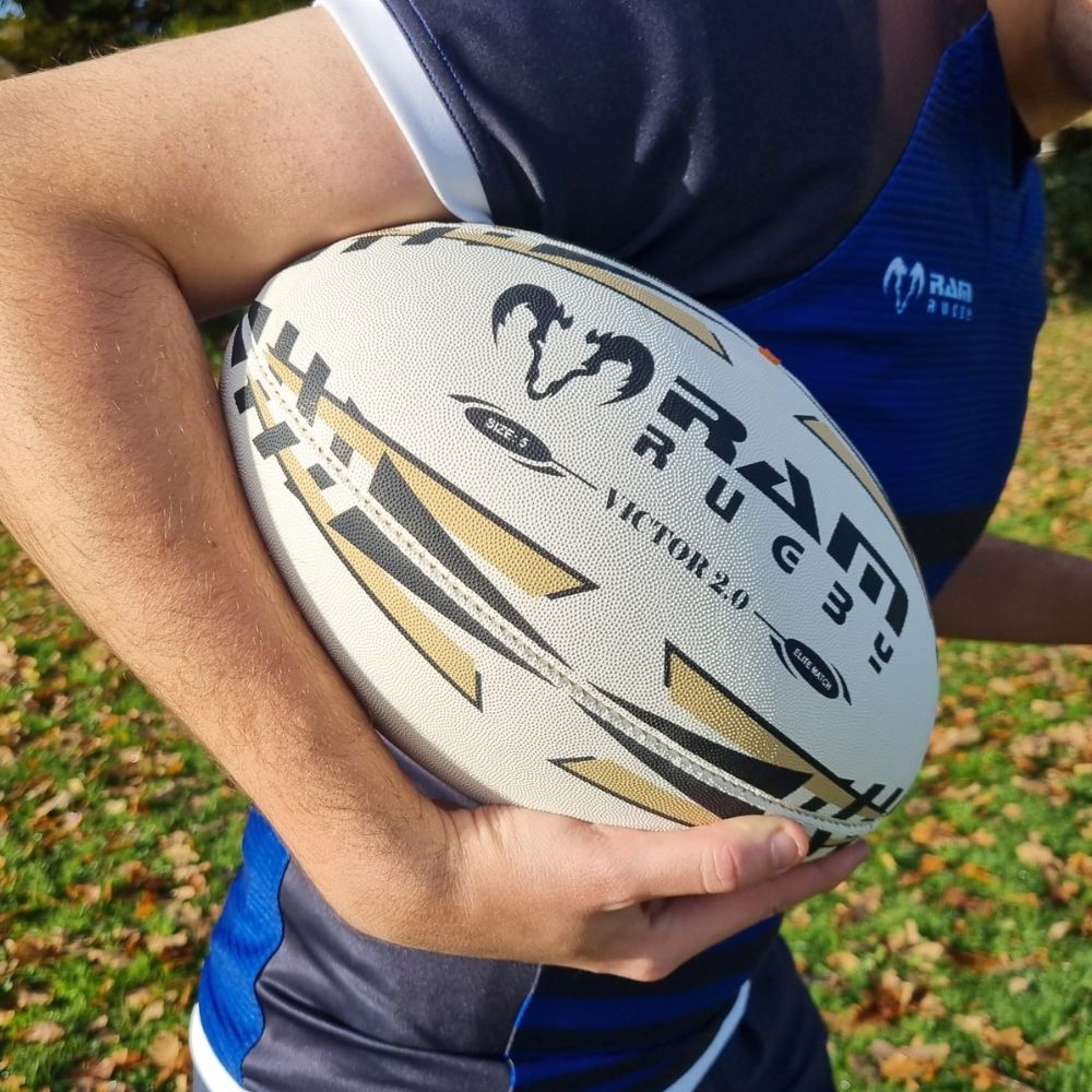 Ram Rugby Victor 2.0 Elite Match Rugby Ball in white and blue with 3D grip, durable polycotton and rubber construction